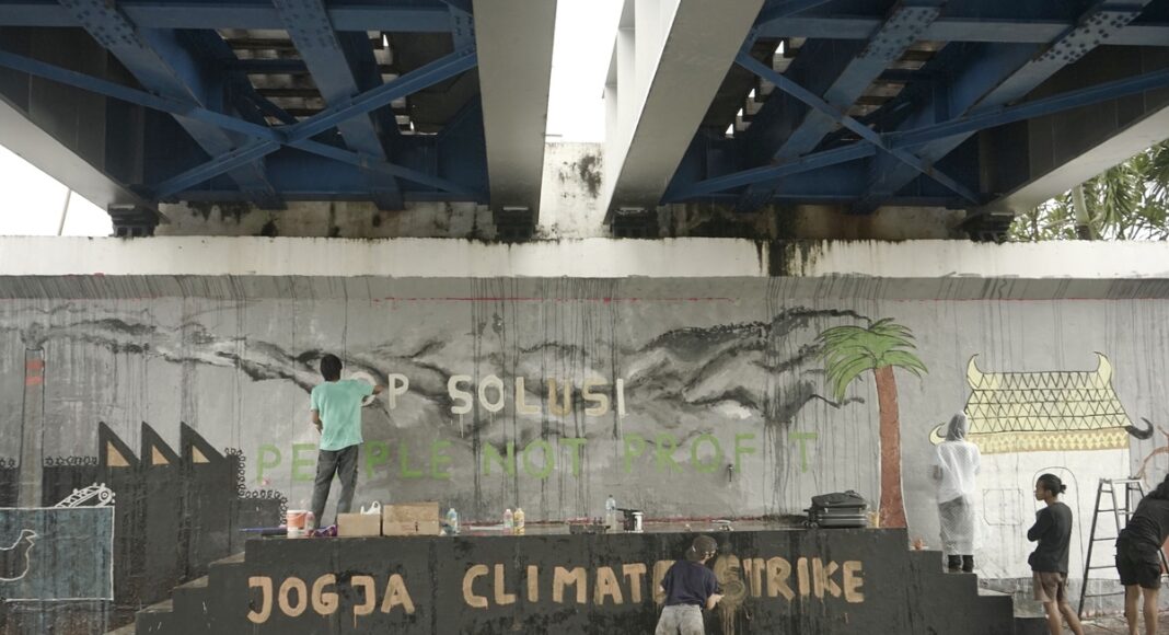 Aksi pembuatan mural Yogyakarta Climate Strike 2022 oleh Komunitas Mural Fossilfree Jogja, untuk menyamarakkan Global Climate Strike di Jembatan Kewek pada Kamis (24/03). Foto: Himmah/Muhammad Mufeed A.